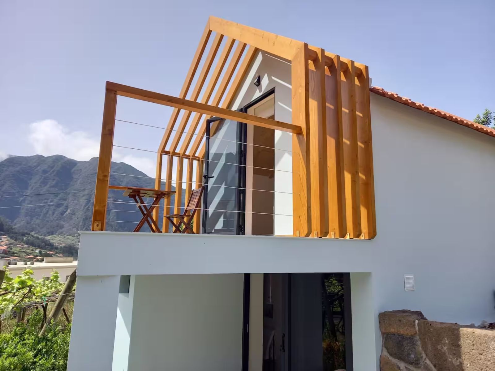 Fachada do chalé com a varanda em madeira